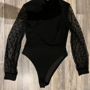 Body - Svart body med låg polokrage. Storlek 36/S i jättefint skick. 