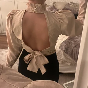 Blus med polokrage  - Beige/puderrosa blus med öppen rygg. Strl 36 från ginatricot💕 helt oanvänd, endast provad! Dubbeltyg så går hur bra som helst att använda utan bh 💕