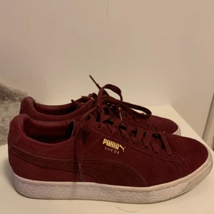 PUMA SUEDE Sneakers Red  - Ett par trendiga Puma Suede Sneakers i färgen vinröd. Dessa är i storlek EU40 och är använda ett fåtal gånger för längesedan. En liten missfärgning på högerskon (se bild 3). Annars ett par super sköna sneakers med en härlig färg till våren/sommarn. Köpare står för frakt. 