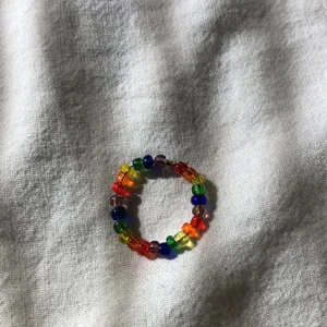 Handgjord regnbågsring. - En handgjord regnbågsring med pärlor. Väldigt fin. Kan ändra storlek och färger på pärlorna efter önskemål. Det är bara att kontakta mig.