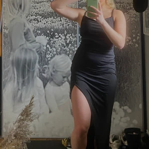 Svart balklänning - Jättefin omlott balklänning. Svart, lång, omlott, slits vid benet, fina detaljer med skrynklor som kramar om midjan jättefint. Slutsåld på hemsidan!