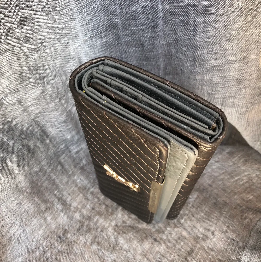 Fake YSL plånbok i silver/brons med detaljer i metall, använd en gång. Superbra med många fack där man får plats med allt! . Accessoarer.