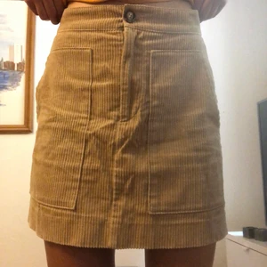 Manchester kjol  - En beige/brun Manchester kjol med stora fickor fram. Den är hög i midjan och otroligt skön. Tyvärr är den lite för stor för mig i midjan så därför har jag knappt använt den. Jag är 173 cm och bär vanligtvis S eller M. 