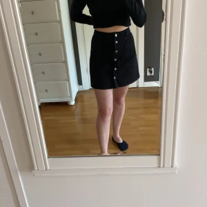 Högmidjad kjol - Svart högmidjad jeanskjol från Pull & Bear i storlek S. Knappar framtill. Jag är 165 cm lång.