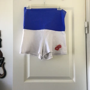 Mörkblå shorts storlek M - Ett par mörkblåa shorts storlek M. Byxorna är stretchiga och går att dubbelvika, därför passar de flera storlekar. Viker man över får man en blomma på baksidan (se andra bilden). Shortsen är ljusare i verkligheten än vad man ser på bilden. Byxorna passar perfekt till träning under sommaren och är i jättebra skick. Finns några små vita fläckar på shortsen där den blåa delen möter den vita, men de syns inte mycket. Frakt ingår ej 
