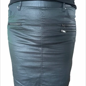 Kjol - Kort kjol i jeans-aktigt material, cropped (halvglansig yta). Aldrig använd. Soaked in luxury, stl 44. Längd 53 cm. Köparen står för frakten.
