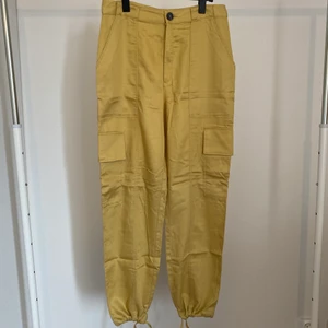 Cargobyxor Monki - Oanvända cargobyxor i mjukt material med snörning vid bensluten från Monki. Praktiska fickor på sidorna.