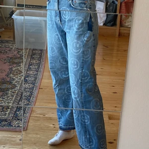 Jeans med smileys - Säljer nu dessa jeans som jag fixat till själv, och som därför inte alls är helt perfekta, men det är enligt mig en del av charmen! Ganska baggy i modellen och inte direkt         ”form-fittting”. Ganska korta för mig som är 175! Har även sytt in ett resårband i midjan för att de ska kunna sitta lite tightare. Bara att Skriva om ni har ytterligare frågor!          OBS!!! Eftersom jag lagt till tyg så är storleken inte helt korrekt!