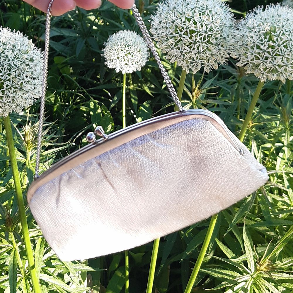  The bag was bought recently and never used,, it is in excellent condition. It has an opening in the middle and has a white silver glittery fabric on the outside and comes with a nice narrow silver bag strap (budgivning i kommentarsfältet). Väskor.