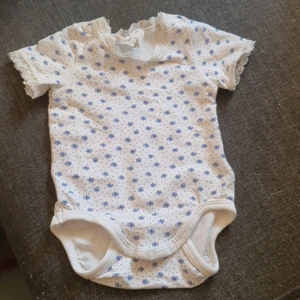 Body - Säljer en blommig body med spets som är i gott skick som är använd någon enstaka gång.