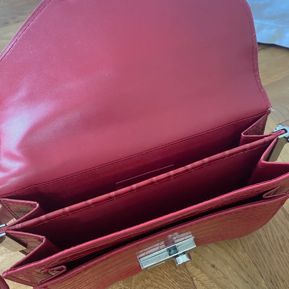 Säljer en röd axelbandsväska i bra skick. Två fack i väskan. Frakt tillkommer! . Accessoarer.