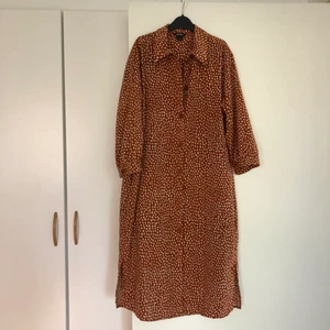Fin prickig klänning från Monki - Rostfärgad/orange klänning med prickar från Monki. Använd en gång. Stl S och säljer den för 100:-
