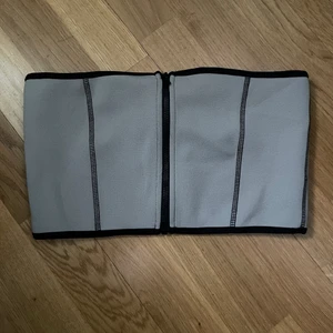 Korsettbandå  - ”Scuba tube top” från weekday. Aldrig använd. Gråbeige färg med dragkedja framtill. 