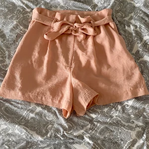 Rosa shorts - Ett par jättegulliga tygshorts från bikbok. Jag köpte dem från Plick men gillade inte hur de satt på mig. Dem har en slitning i grenen men den syns inte när man har shortsen på sig. Köparen står för frakten🥰