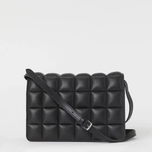 AXELREMSVÄSKA SVART IFRÅN HM - En axelremsväska med lock. Väskan har smalt, reglerbart axelband. Ett innerfack med dragkedja. Fodrad. Djup 10 cm. Höjd 17 cm. Bredd 24 cm. Nypris 199:- Komposition: Ytterlager: Polyester 100%Foder: Polyester 100%Coating: Polyuretan 100%