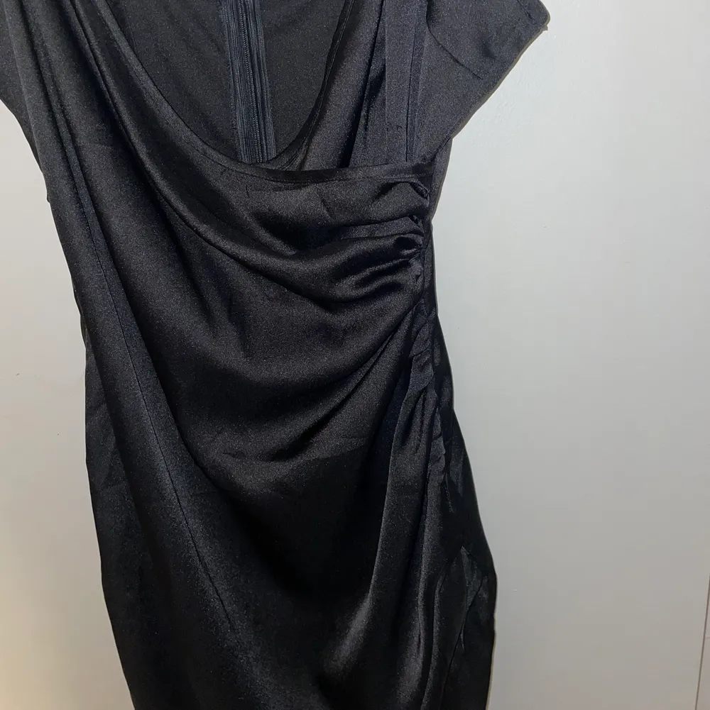 Svart silkesklänning med slits och urringning. I storlek 36. Knappt använd, mycket fint skick. Klänningar.