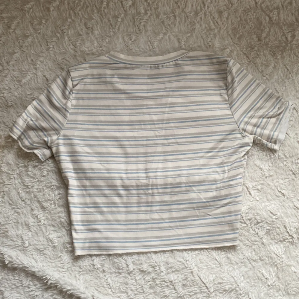 Supersöt randig t-shirt från Shein. Ränderna är i färgerna ljusblått, beigt och grå. Toppen är en aning croppad.. T-shirts.