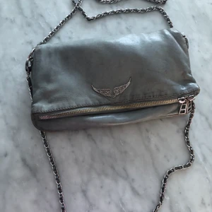 Zadig väska - Superfin elefant grå Zadig väska, den är sliten på ett antal ställen. Båda kedjorna tillkommer. Säljer pågrund av att jag har tröttnat på den! ❤️ kan även byta mot en annan väska!!