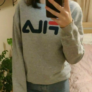 Grå FILA tröja  - Mysig tröja från fila. Köpte för 600 kr på originalpris, och har bara använt 2 gånger. Säljer eftersom jag aldrig får nytta av den. Storlek XS, men passar mig fint som brukar ha S i vanliga fall. 