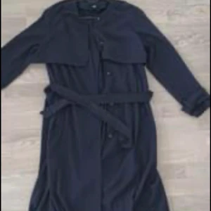 Marinblå trenchcoat - Säljer min marinblå trenchcoat från HM! Använd men sitter perfekt och är superskönt att ha till våren. 