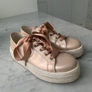 Glansiga sneakers - Superfina glansiga sneakers med siden snören från K Cobler! Dom är högsulade och i fint skick, bara använt ett fåtal gånger. Strl 37, köparen står för frakt. Skriv privat om du är intresserad eller för mer info🤎🤎🤎