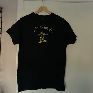 En thrasher t shirt med gult tryck 