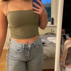 Grönt linne från Ginatricot - Säljer detta gröna linne från ginatricot då det inte kommer till användning längre. På första bilden är det spegeln som är lite smutsig och inte toppen som är fläckig.💕