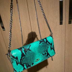 Zadig väska - Säljer denna super coola snakeprint Zadig&Voltaire väskan, den är grön med silvriga detaljer🖤💚 Det finns två kedjor , en lite länge om man vill ha den crossbody men det finns också en kortare kedja till för att ha den på axeln!! Den är mycket sparsamt använd och i mycket bra skick, köpte väskan för 3600kr💚💚 Skriv om du vill ha fler bilder🥰