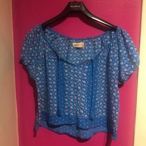 Blå blommig sommarblus🌺💙 - Supersöt sommarblus från Hollister✨ lappen säger storlek XS men passar XS-M Med tofsar som kan knytas eller lämnas hängande