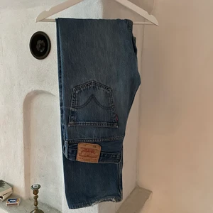 Vintage Levis jeans  - Ett par fina vintage Levis Jeans i bra men använt skick, finns lagningar på vissa ställen ett litet på knät som man inte ser och sen nån i skrevet. Storlek 33/36