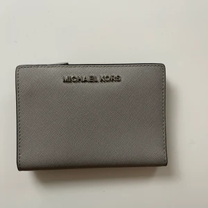 Michael Kors plånbok - Nästintill oanvänd plånbok från MK, äkta men finns tyvärr inget kvitto då den är köpt i USA. Ett fack med dragkedja och flera fack för kort. 