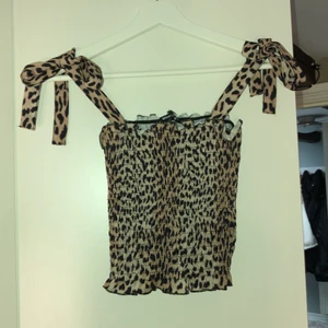 Sommartopp från ginatricot - Söt kortare topp med rosetter på axelbanden. Använd fåtal gånger, storlek M passar även till S! Ej använd på ett år därav säljer, perfekt till sommaren :)