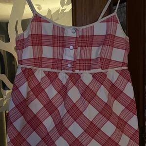 Peak Performance  - Ljuvligt linne från Peak Performance, kvalitet som verkligen håller! Vit och roströd (röd/orange) rutigt och hur fint som helst! Söta knappar framtill och dragkedja på sidan. Storlek S. Fint broderat Peak Performance på ryggen. Inte ny men känslan är ny. 