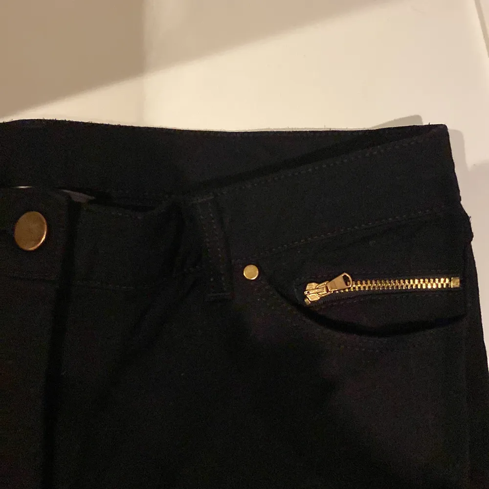 Ett par svarta skinny jeans med guldiga detaljer. Ganska stretchiga.. Jeans & Byxor.