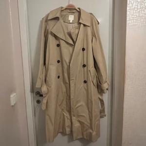 Trenchcoat  - Superhärlig trenchcoat från h&m säljes. Fint skick och inga fläckar eller dylikt, säljs billigt då det fattas ett ”bälte” till ena ärmen (se bild nr: 3). Strl: XS, men sitter toppen på mig som är en normal S. 