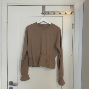 Topp med volang  - Fin brun beige tröja med volang från nakd. Använd en gång. 