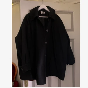 Kortare kappa  - En svart kortare kappa från weekday. Använd men i fint skick! 