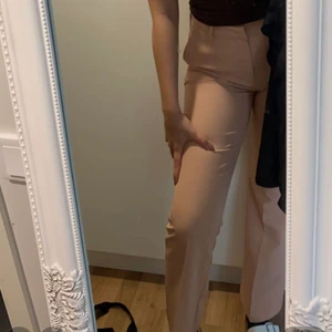 Beige/rosa kostymbyxor  - Trendiga kostymbyxor från bikbok, jätte bra passform. Dom är tighta runt midjan och låren men går rakt ner. Ganska långa (jag har långa ben och dom går över anklarna). Säljer pga att dom blivit för små :/ 