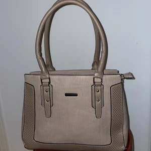 Väska  - Säljer denna super snygga brun beigea väska som jag använt ca 2 gånger. Den är i en perfekt storlek då den inte är för liten men inte för stor. Den har två stora fack ( se på andra bilden ) med små fack inuti också. Den har även ett längre band som man kan sätta på om man kansk bär på något tyngd eller vill ha den som en sido väska mm. 