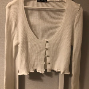 Nastygal - kofta  - Vit kofta från Nastygal i ribbat material med knappar. Aldrig använd. Den är väldigt uringad. Den är typ vågad längst nere vid armarna och vid slutet av koftan. Liten i storleken. 