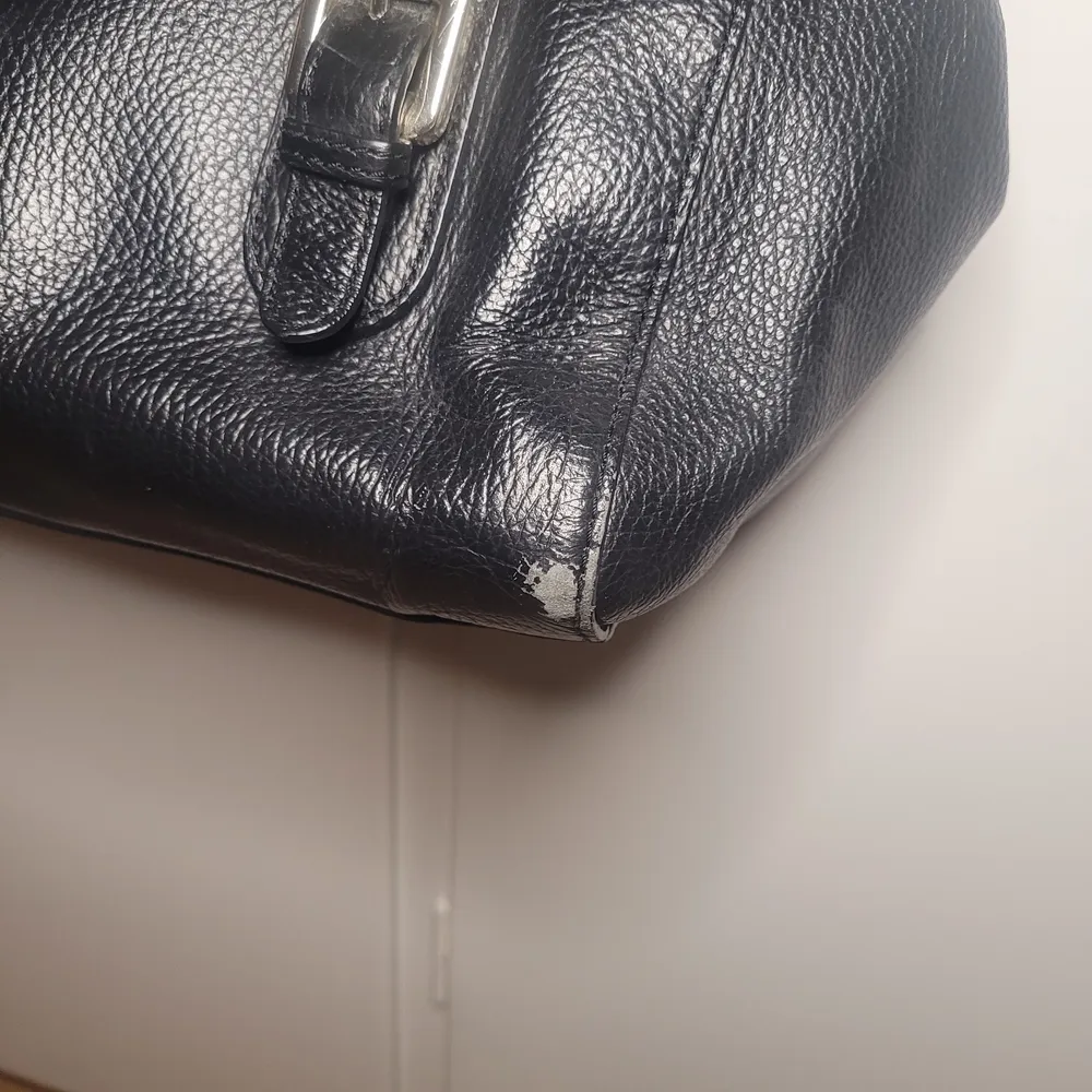 Guess handväska med lite slitage på metallen och på kanterna av väskan(se bilder). Även ett axelband som aldrig använts hänger med.  34×18×18cm. Väskor.