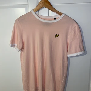 Lyle and Scott t-shitt - Superfin & OANVÄND t-shirt från Lyle and Scott. Bilderna missvisar färgen lite, den är väldigt fin ljusrosa, med de vita detaljerna & den gula Lyle and Scott märket. 💕 Tröjan är i strl L men passar M. Skicka privat vid intresse. Köparen står för frakten. 