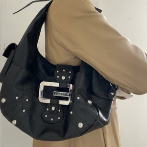 Guess väska - Svart handväska från guess som går att bära under axeln. Skitsnygg med silverdetaljer och rymlig😍😍