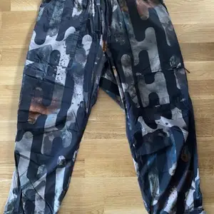 The Camo Allover Print Pants is crafted from smooth ripstop with a variety of pockets throughout. Expressive camouflage artwork creates a lyrical aesthetic.  Condition 10/10