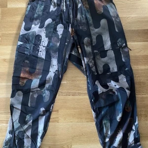 Adidas Y-3 - The Camo Allover Print Pants is crafted from smooth ripstop with a variety of pockets throughout. Expressive camouflage artwork creates a lyrical aesthetic.  Condition 10/10