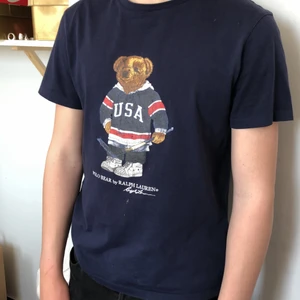 Ralph lauren Bear t-shirt blå - Ralph lauren t-shirt i blå färg. Skriv om du är intresserad. Mycket tvättad men annars bra skick. Storlek S/ liten M 