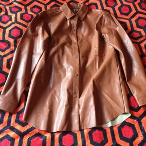 ASOS - skjorta/jacka/skjortjacka av konstläder/vegansk i färgen cognac (36/S) - Märke: ASOS Modell: Off-size skjortjacka Storlek EU 36 Skick: Ny med tags Färg: Cognac