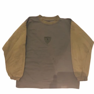 Vagabond - Vintage Sweatshirt - En gul och lite beige färgad sweatshirt med ett emblem i mitten som ger lite 80’s och 90’s känsla. Köpt på Ross som är en secondhandbutik i USA. Om du har några frågor gällande plagget eller priset kontakta oss!