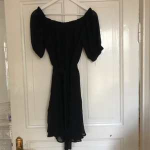 Klänning från NAKD! - Använd två gånger! Bra skick! Fint fall med skärp i midjan. Off shoulder. Ena hölsan till skärpet är sönder men klänningen ser likadan ut ändå!