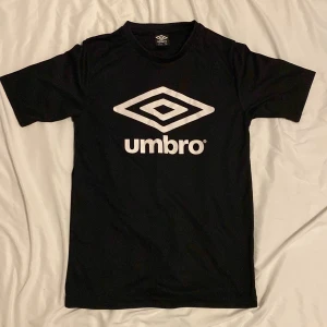 Umbro elastisk idrotts T-Shirt  - Säljer pga för liten, använd endast någon enstaka gång och är i storlek 164, Den är svart med vitt tryck